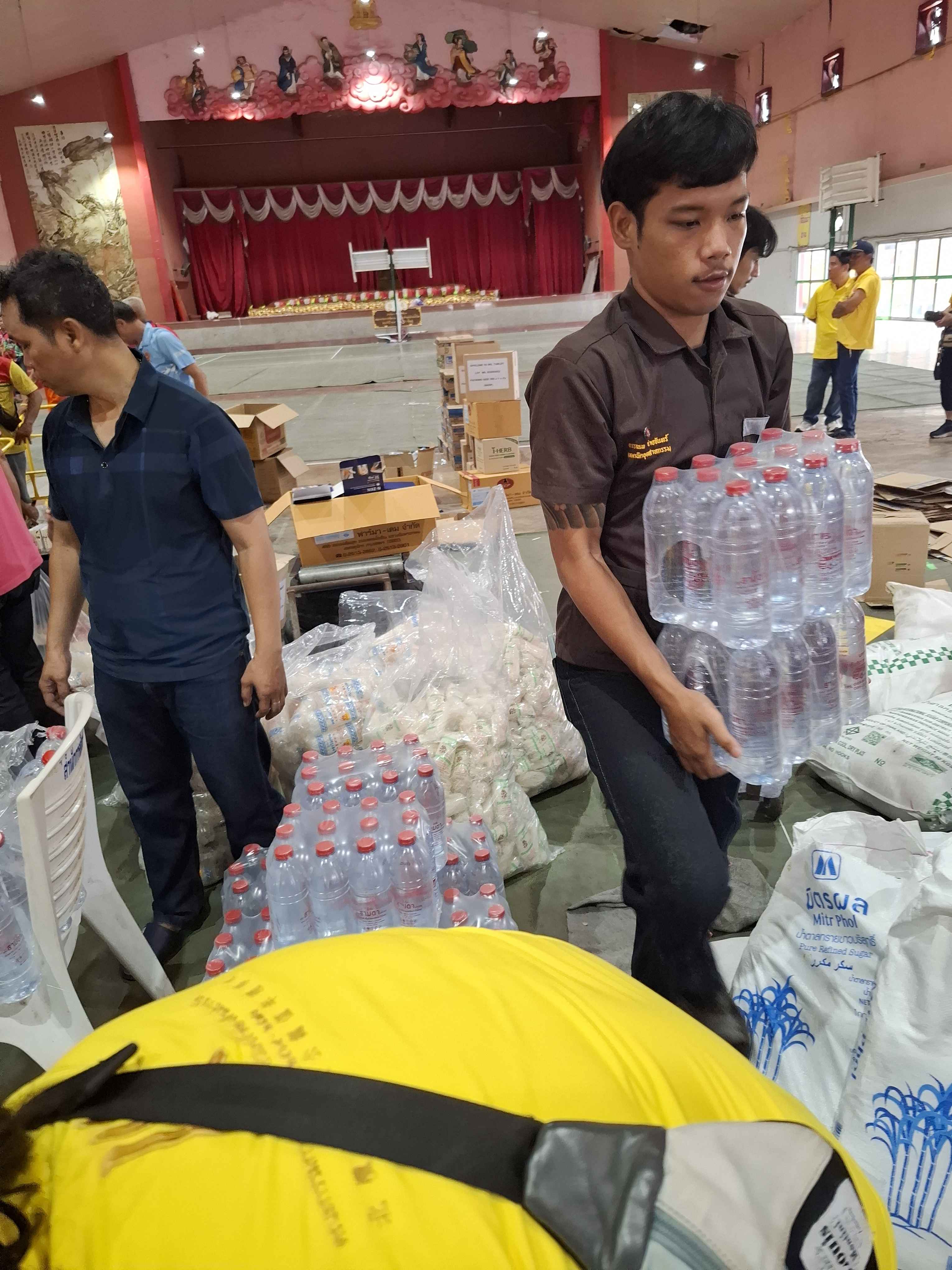 นักศึกษาถือน้ำดื่มบรรจุขวดเตรียมนำไปบรรจุลงถังสังฆทาน