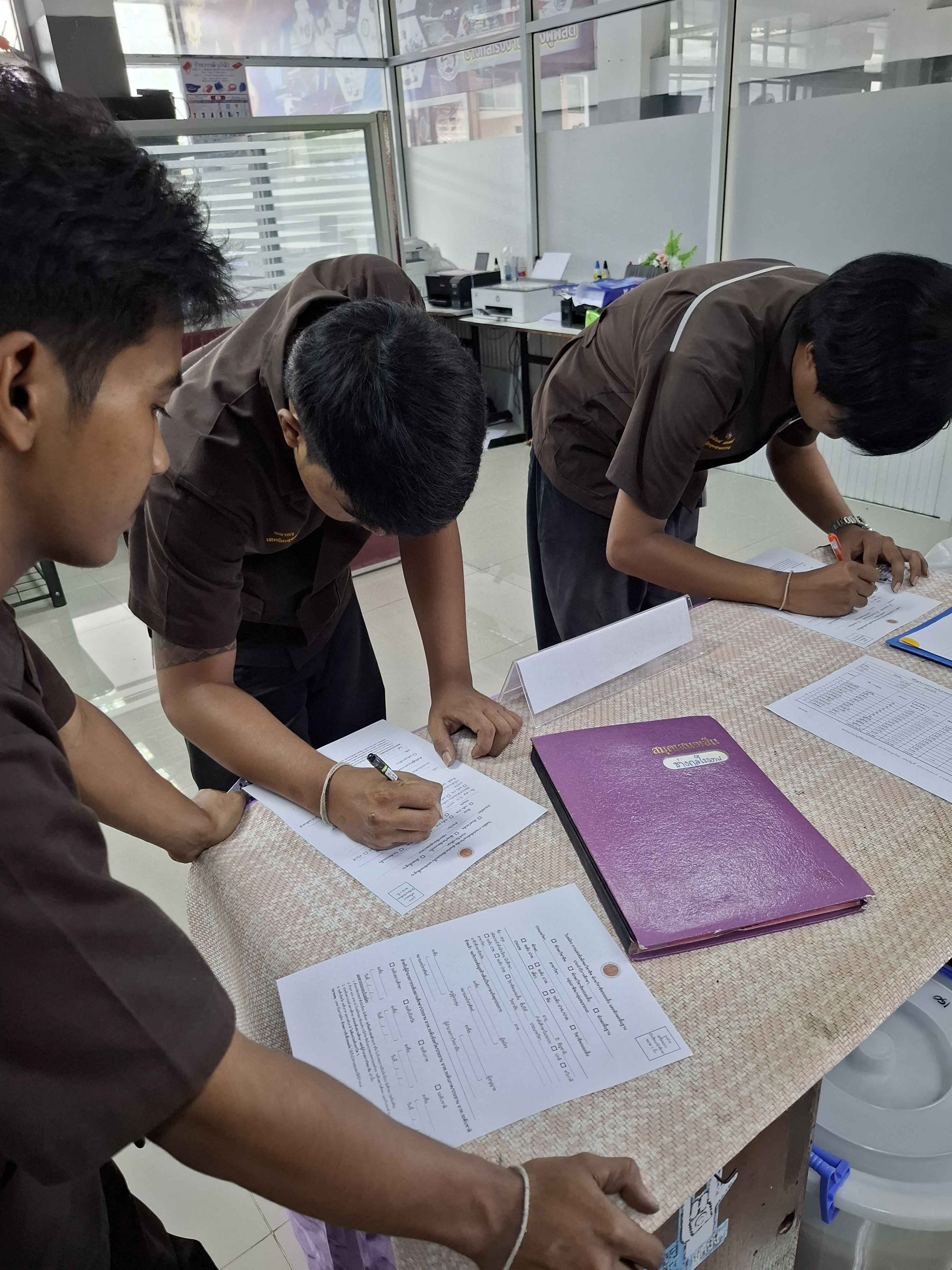 คณะกรรมการตัดสินการแข่งขันทักษะมาตรวิทยามิติ นั่งหน้าโต๊ะพร้อมเครื่องมือวัดละเอียด